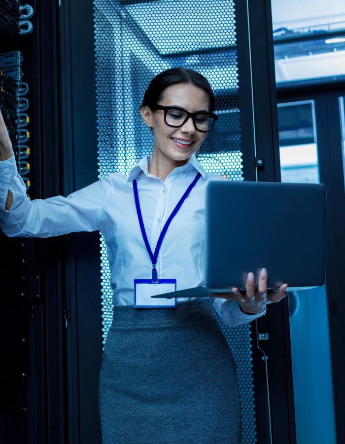 amazing-day-happy-beautiful-woman-working-in-a-server-cabinet-and-holding-her-laptop